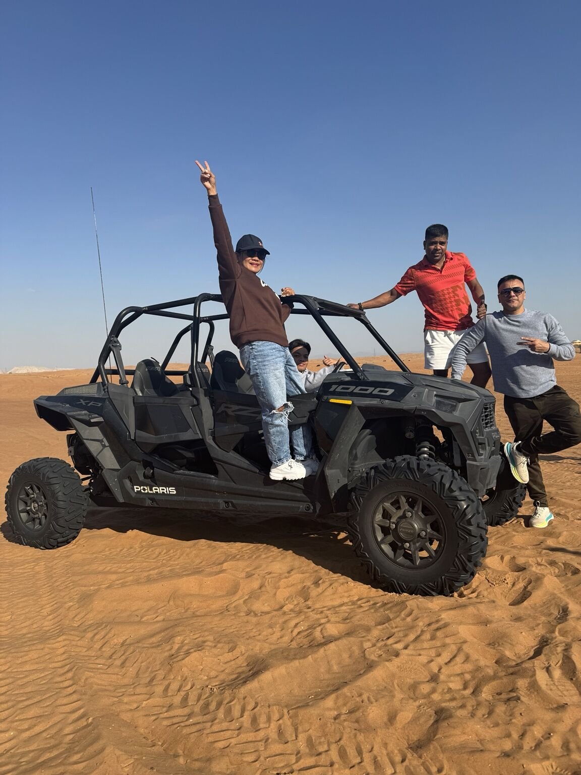 Guests with a four-seat Polaris family dune buggy in the Dubai desert